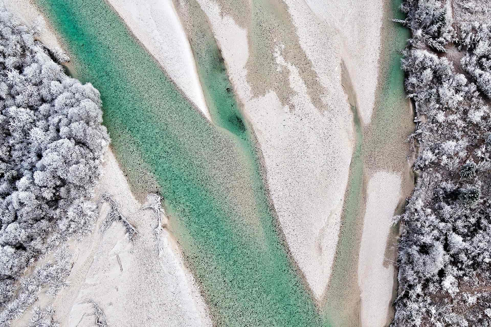 Aerial view of the emerald Soča river winding through the Slovenian alps